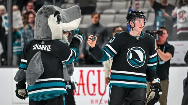 San Jose Sharks mascott S.J. Sharkie fist bumps Collin Graf after a victory.