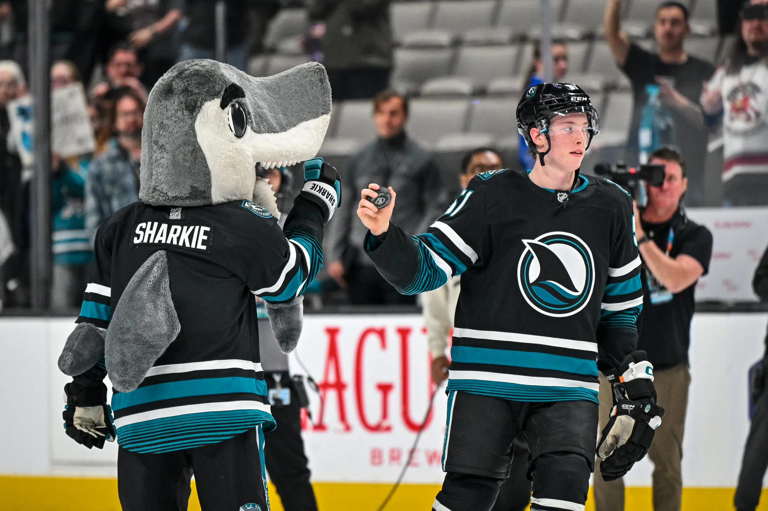 San Jose Sharks mascott S.J. Sharkie fist bumps Collin Graf after a victory.