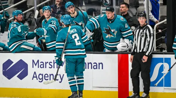 San Jose Sharks forward Will Smith skates by the bench after scoring.